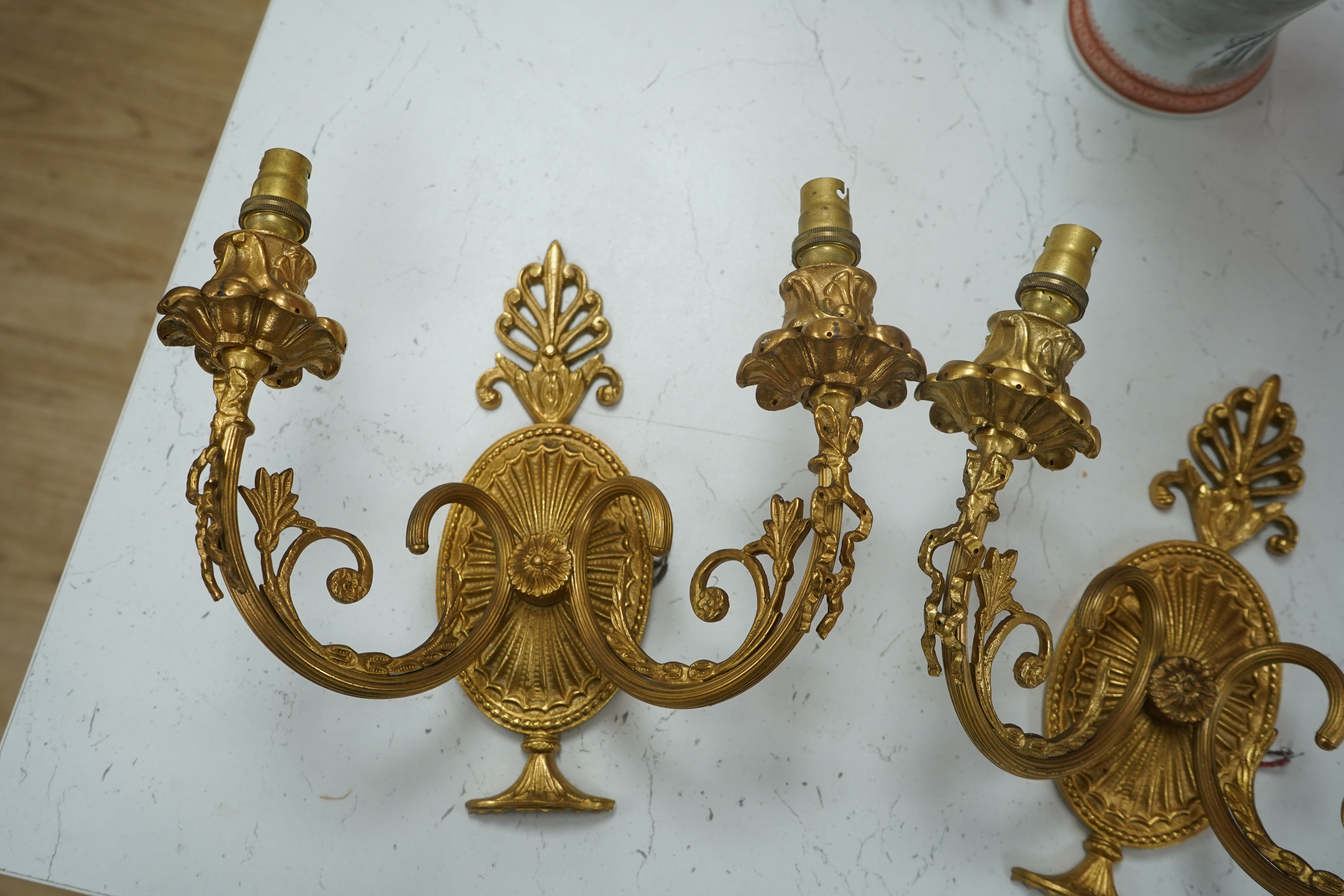 A pair of Adam style gilt brass twin branch wall lights, 23cm long. Condition - good